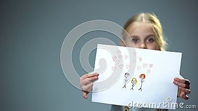 Cheerful little girl showing family picture into camera, feeling parental love Stock Photo