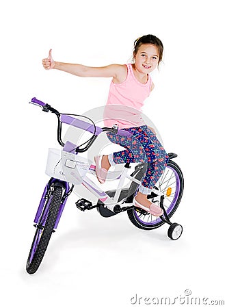 Cheerful little girl on a sports bike on a white background Stock Photo