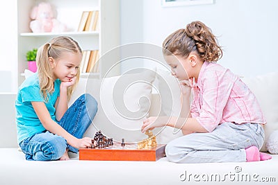 Cheerful little sisters sitting on the sofa Stock Photo