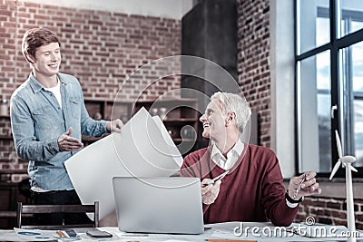 Cheerful male engineers improving blueprint Stock Photo