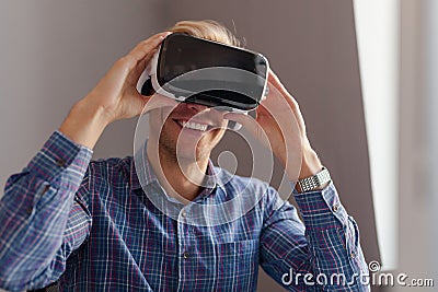 Cheerful man adjusting VR headset Stock Photo