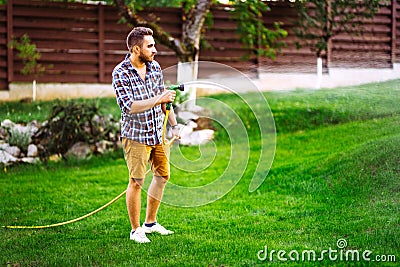 Cheerful man, caucasian male watering home garden Stock Photo