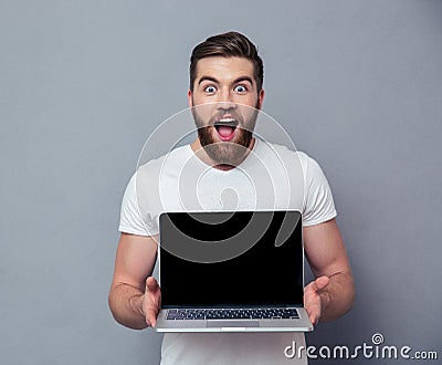 Cheerful man showing blank laptop computer screen Stock Photo