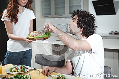 Cheerful married couple eating tasty foot at home Stock Photo
