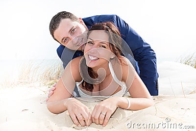 Cheerful married couple lying on the beach Stock Photo