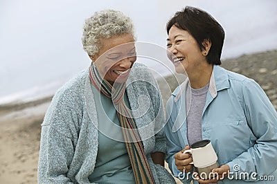 Cheerful Middle Aged Female Friends On Beach Stock Photo