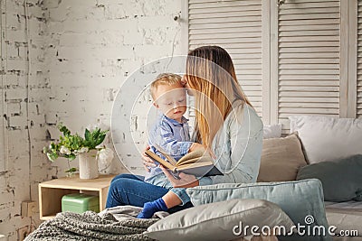 Cheerful Mother and Son Reading a Book at Home Stock Photo