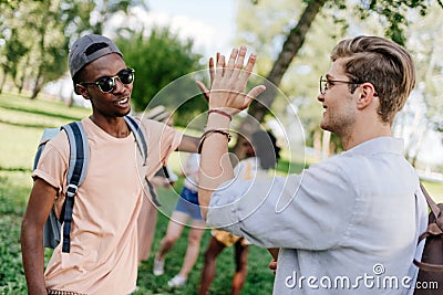 Multiethnic boys giving high five while meeting in park Stock Photo