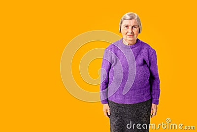 Cheerful octogenarian woman on yellow background with copy space Stock Photo