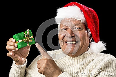 Cheerful Old Man Pointing At Green Wrapped Gift Stock Photo