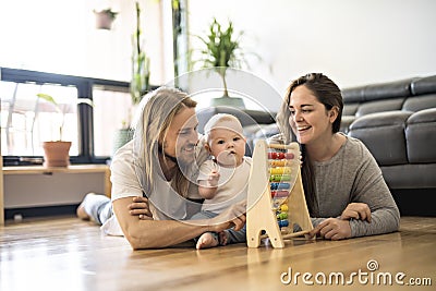 Cheerful parent playing with his baby girl on floor at living room Stock Photo