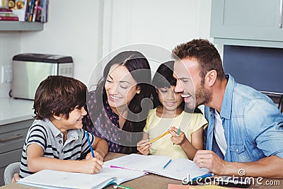 Cheerful parents assisting children in homework Stock Photo