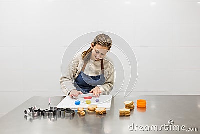 Cheerful pastry chef kneading colored doughs to decorate cookies Stock Photo