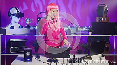 Cheerful performer standing at dj turntables mixing sounds Stock Photo