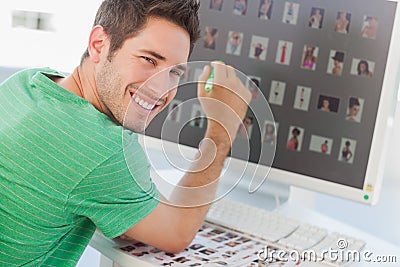 Cheerful photo editor pointing at his screen Stock Photo