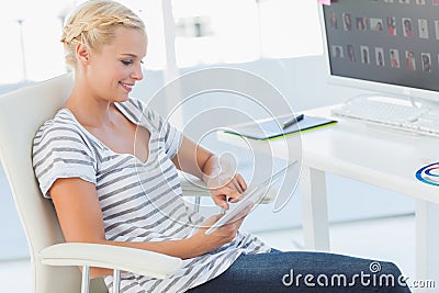 Cheerful photo editor working on a tablet computer Stock Photo