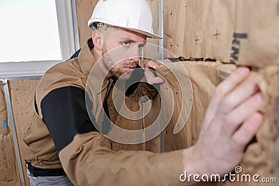 Cheerful plasterer worker at indoors wall insulation works Stock Photo