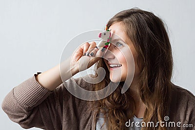 Cheerful positive woman holds a toy unicorn near her forehead Stock Photo