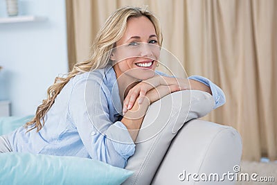 Cheerful pretty blonde sitting on couch Stock Photo