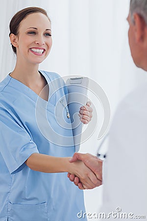 Cheerful pretty surgeon welcoming her new workmate Stock Photo