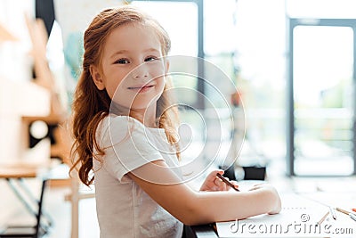 cheerful redhead child smiling and looking at camera. Stock Photo