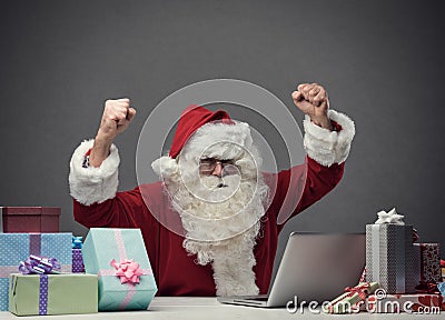 Cheerful Santa connecting with his laptop Stock Photo