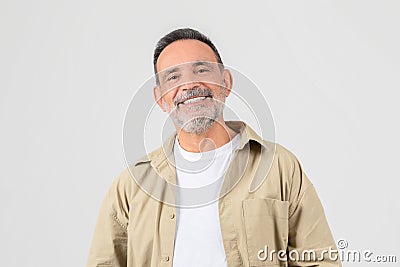 Senior smiling with hands in pockets on white background Stock Photo