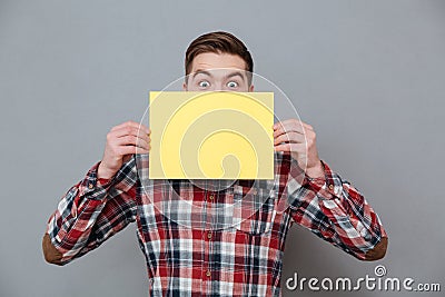 Cheerful shocked young bearded man holding copyspace blank Stock Photo