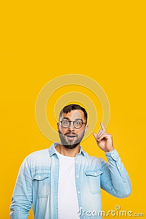 Cheerful smart mature caucasian male with beard in glasses raises his finger up Stock Photo