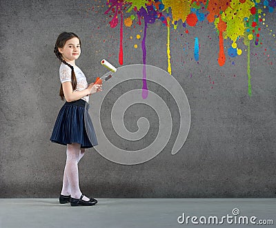 Cheerful smiling young little girl the child draws on the background wall colored paints making a creative repairs. Stock Photo