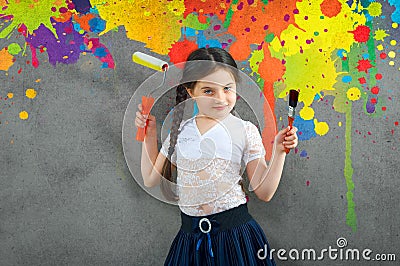 Cheerful smiling young little girl the child draws on the background wall colored paints making a creative repairs. Stock Photo