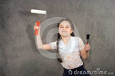 Cheerful smiling young little girl the child draws on the background wall colors making a creative repairs. Stock Photo