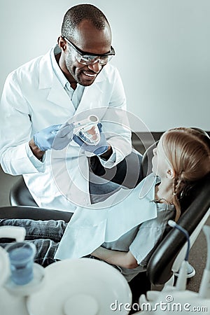 Cheerful stomatologist showing right way of teeth brushing Stock Photo