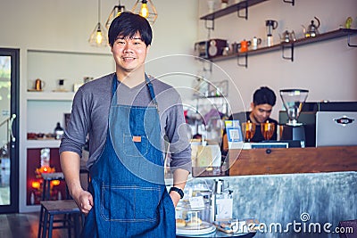Cheerful success Asian barista! - The coffee shop startup owner standing at the coffee counter Stock Photo