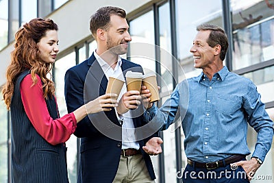 cheerful successful business team clinking with disposable cups Stock Photo