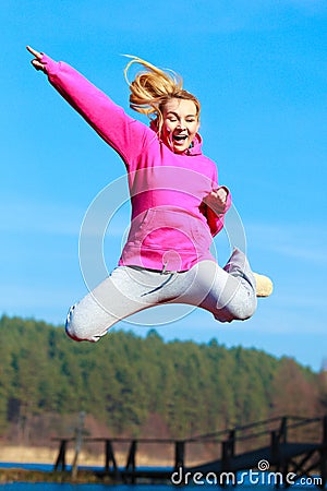 Cheerful teenage girl jumping showing outdoor Stock Photo