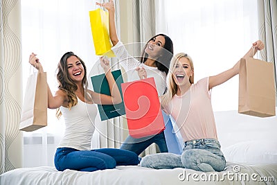 Cheerful three girlfriends with many shopping bags Stock Photo