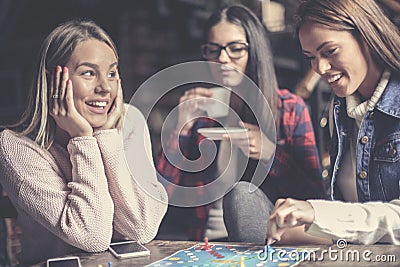 Three happy girls playing board game. Stock Photo