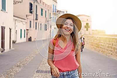 Cheerful traveler girl walking towards the camera on street in old town Stock Photo