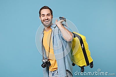 Cheerful traveler tourist man in yellow summer casual clothes with photo camera isolated on blue background. Male Stock Photo