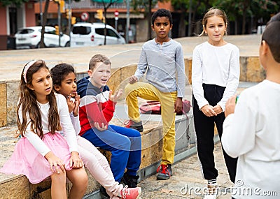 Cheerful tweens spending time together on city street Stock Photo