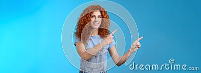 Cheerful upbeat positive summer girl redhead curly hairstyle wear denim overalls getting ready beach vacation pointing Stock Photo