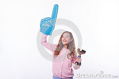 Cheerful winner girl is holding a trophy and foman fan glove. Stock Photo