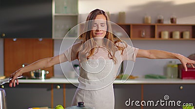 Cheerful woman dancing on kitchen. Housewife having fun at home Stock Photo