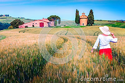 Cheerful woman enjoying the view in grain fields, Tuscany, Italy Stock Photo