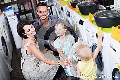 Cheerful woman and man with children shopping washer Stock Photo
