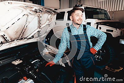 Cheerful Young Auto Mechanic. Opened Hood Concept. Stock Photo