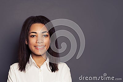 Cheerful young black woman smiling on gray background, face close up Stock Photo