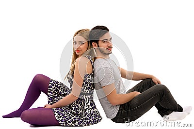 Cheerful young couple sitting with back to each other on floor, Stock Photo