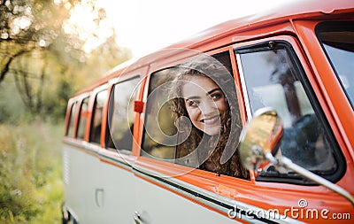 A young girl looking out of a car on a roadtrip through countryside. Stock Photo